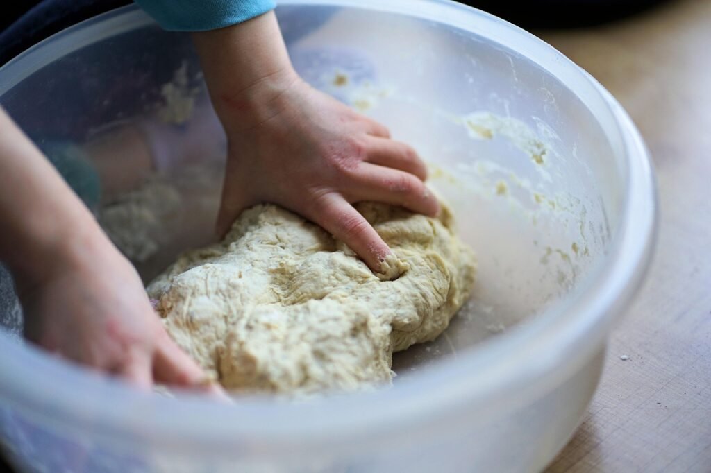 Mains qui pétrissent la pâte à sel dans un saladier